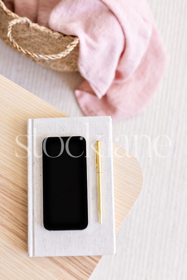 Vertical stock photo of a phone mockup in pink and neutral colors.