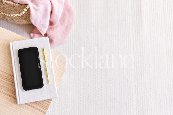 Horizontal stock photo of a phone mockup in pink and neutral colors.