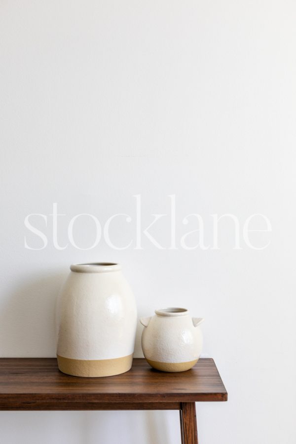 Vertical stock photo of two decorative vases in neutral colors.