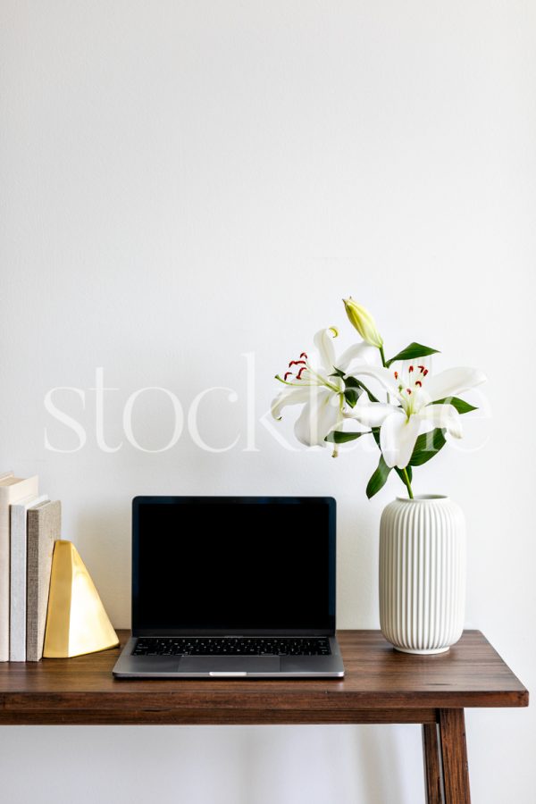 Vertical stock with white asian lilies, books, and a computer