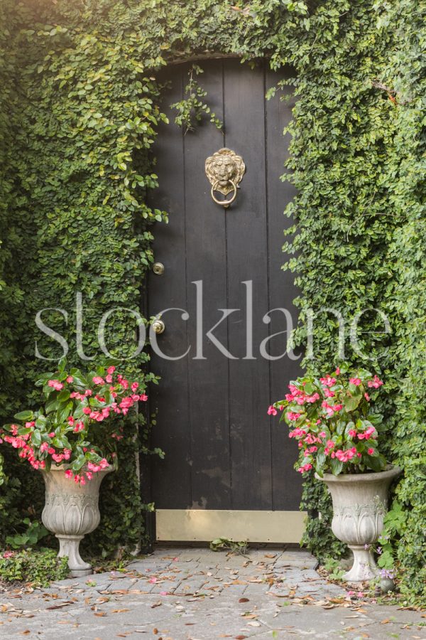 Vertical stock photo of a doorway with a black door.