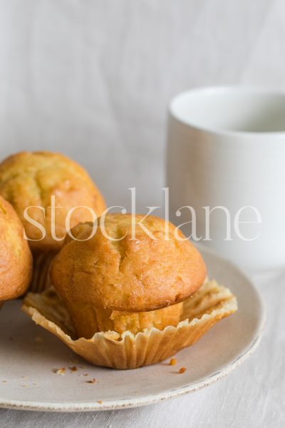 Vertical stock photo of a plate with muffins and a cup of coffee.