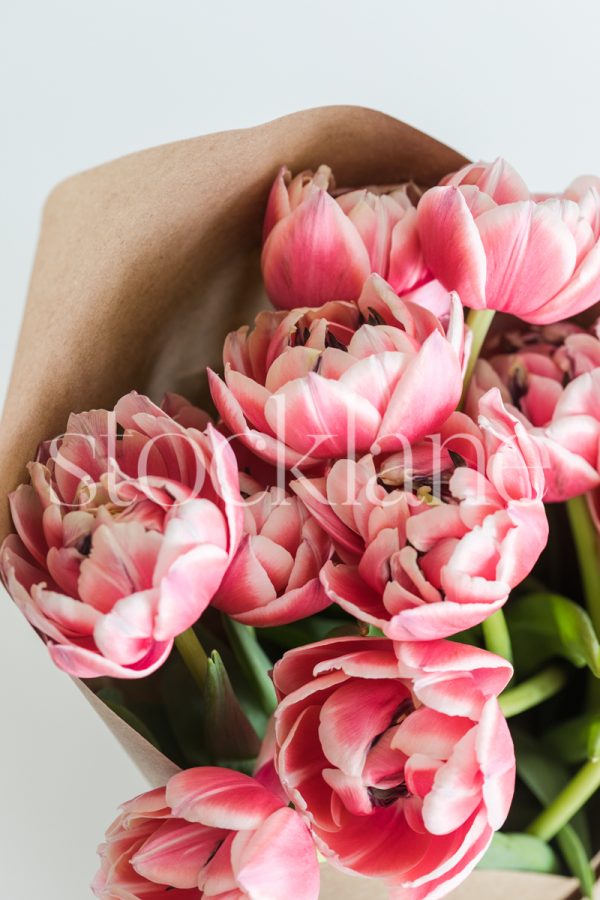 Vertical stock photo of a pink peony tulip bouquet.