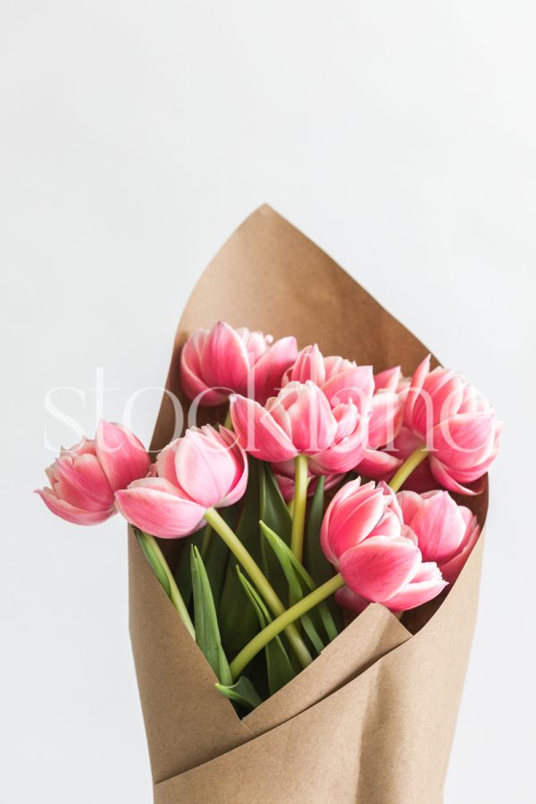 Vertical stock photo of a pink peony tulip bouquet.