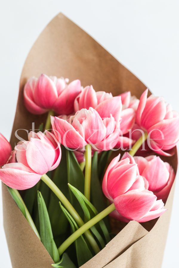 Vertical stock photo of a pink peony tulip bouquet.