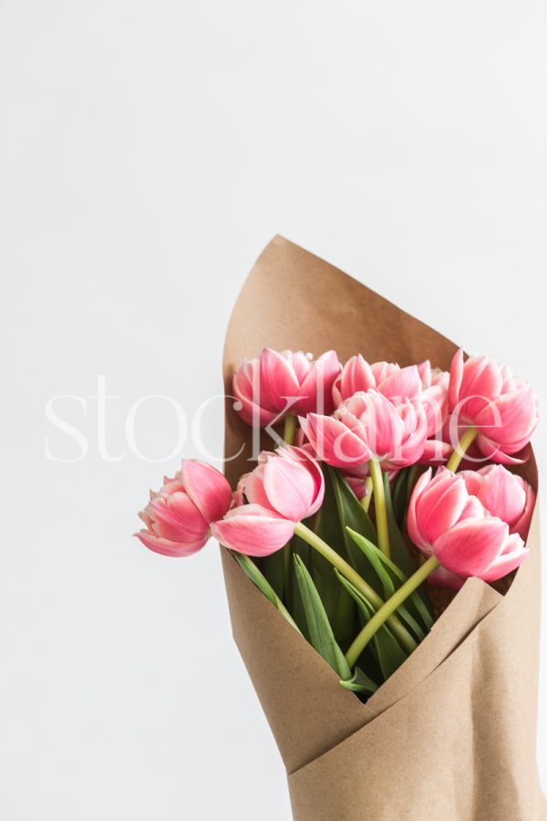 Vertical stock photo of a pink peony tulip bouquet.