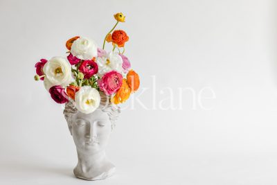 Horizontal stock photo of a sculpture toped with colorful flowers.