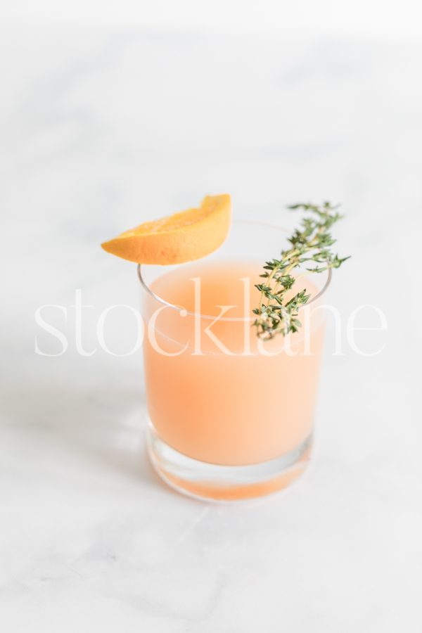 Vertical stock photo of a glass with citrus juice.