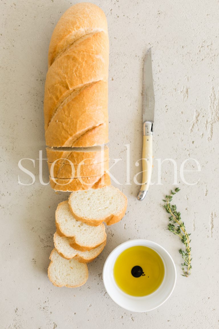 Vertical stock photo of a loaf of bread with olive oil.