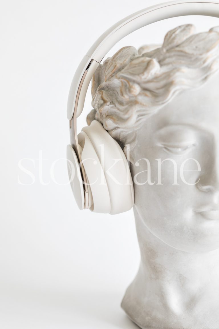 Vertical stock photo of a woman head sculpture with headphones