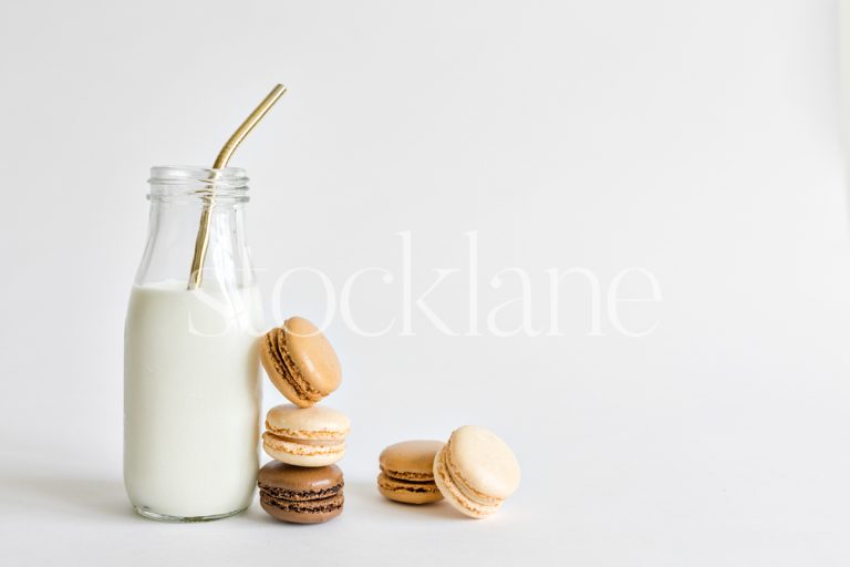 Horizontal stock photo of a milk bottle and macarons.