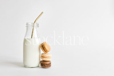 Horizontal stock photo of a milk bottle and macarons.