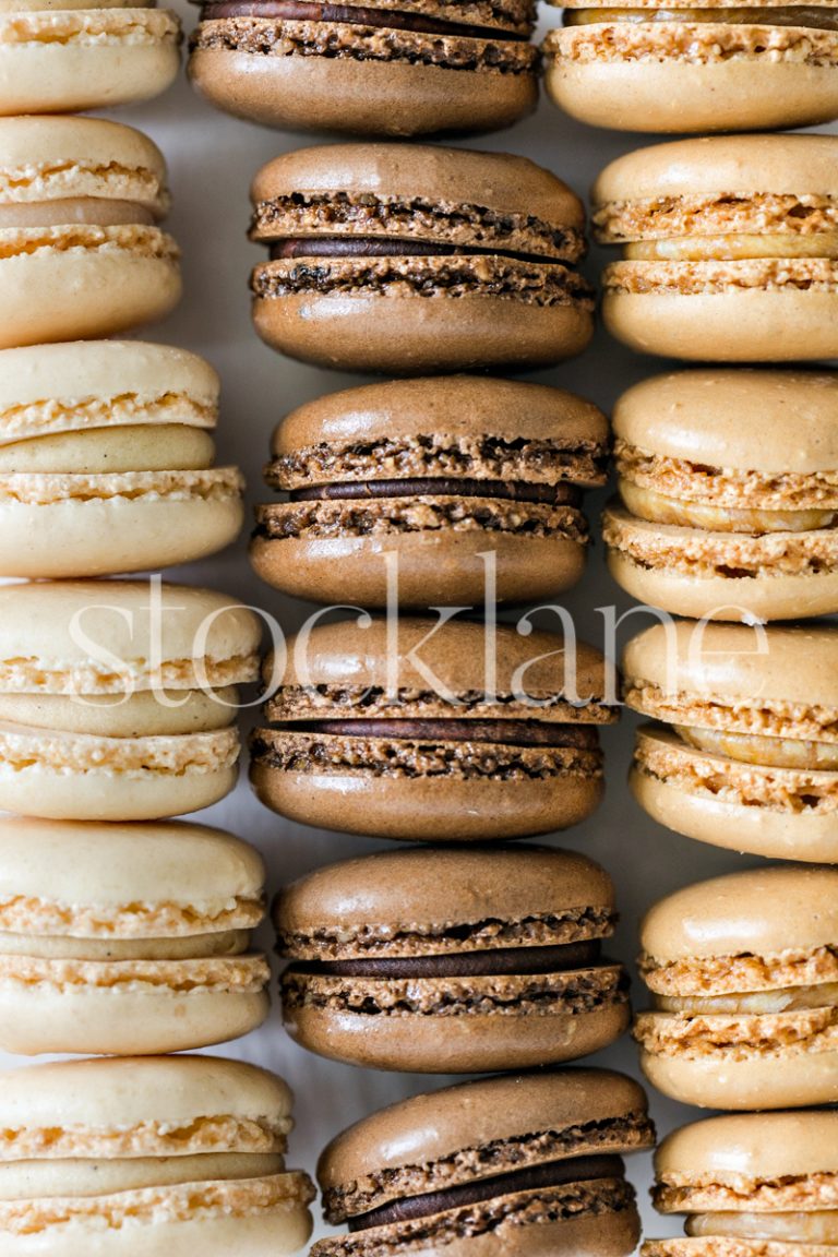 Vertical stock photo of vanilla, chocolate and caramel macarons