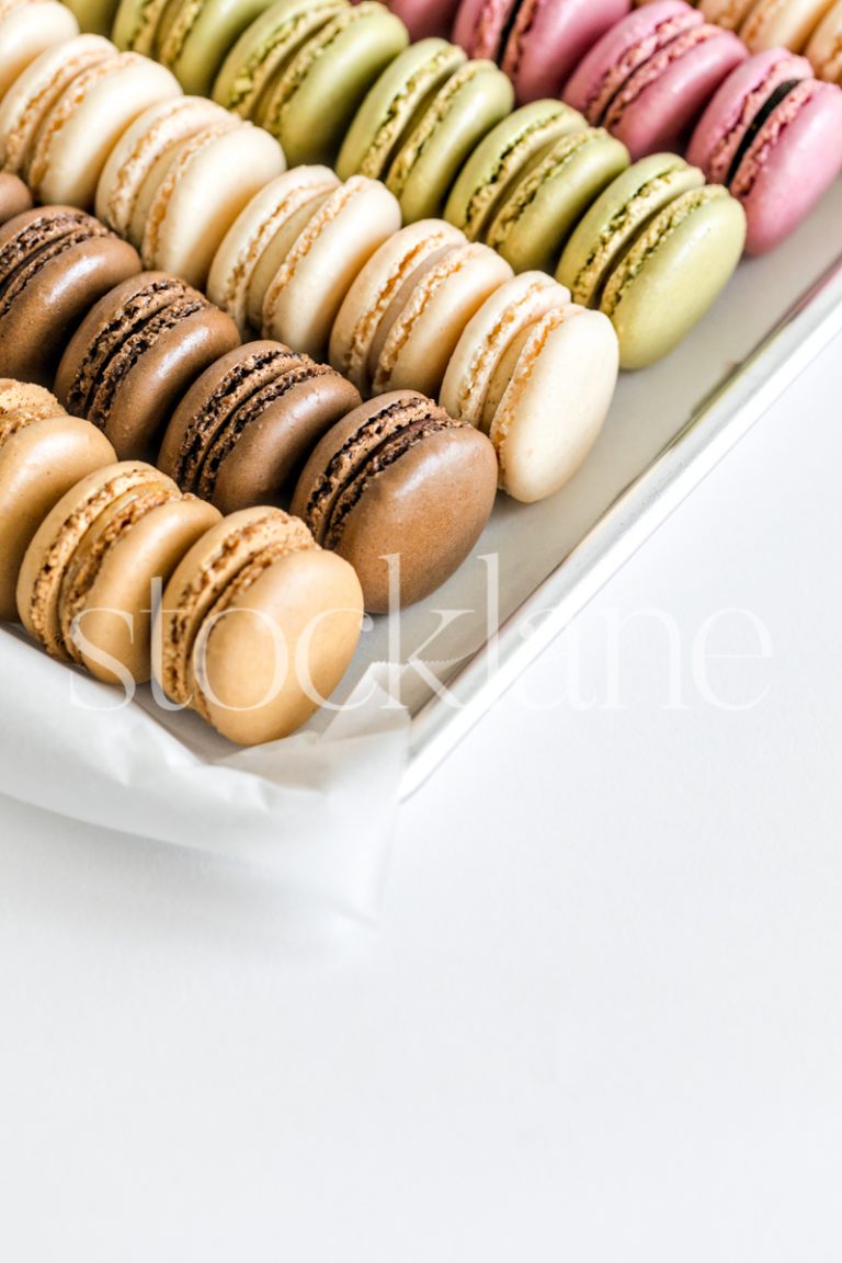 Vertical stock photo of a colorful tray of macarons.