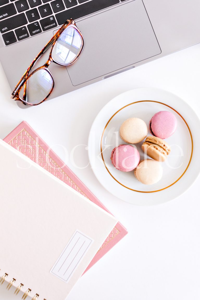 Vertical stock photo of a woman's desktop in blush pink.