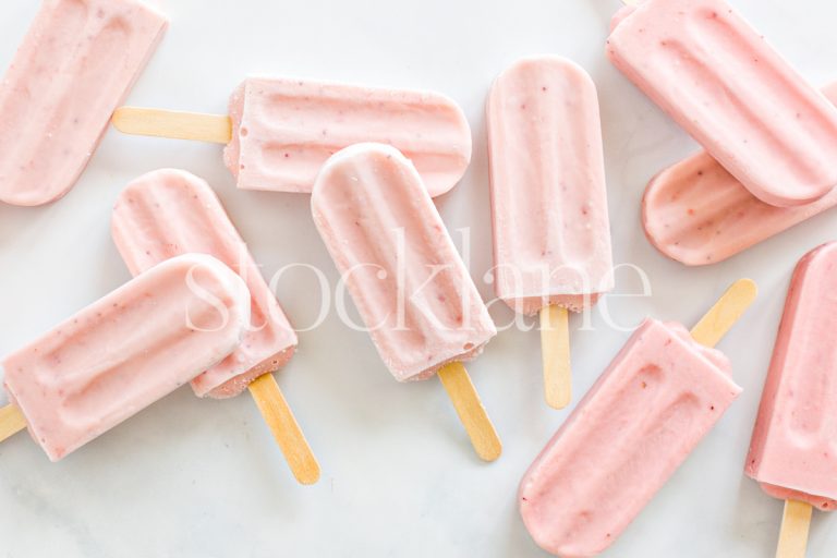 Horizontal stock photo of a bunch of strawberry popsicles.