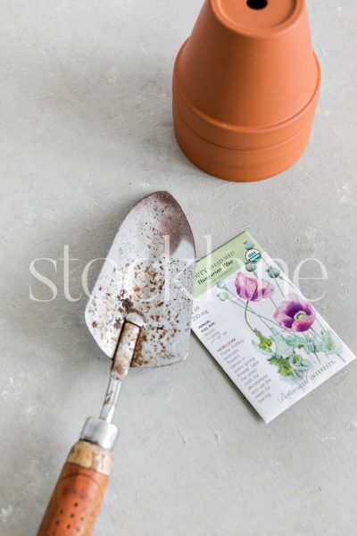 Vertical stock photo of flower pots, seeds and gardening tools.