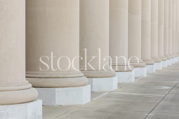 Horizontal stock photo of classic building columns in neutral colors.