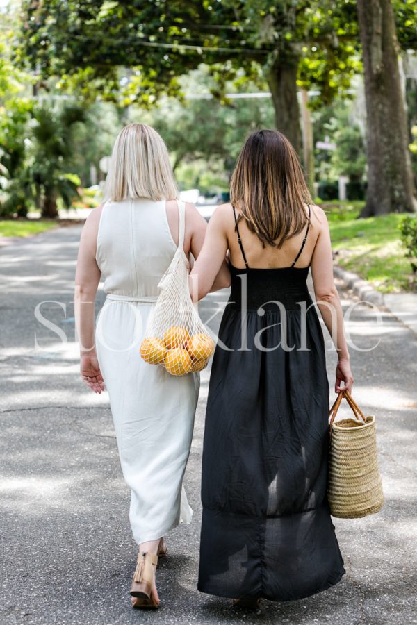 Vertical stock photo of two woman friends walking.