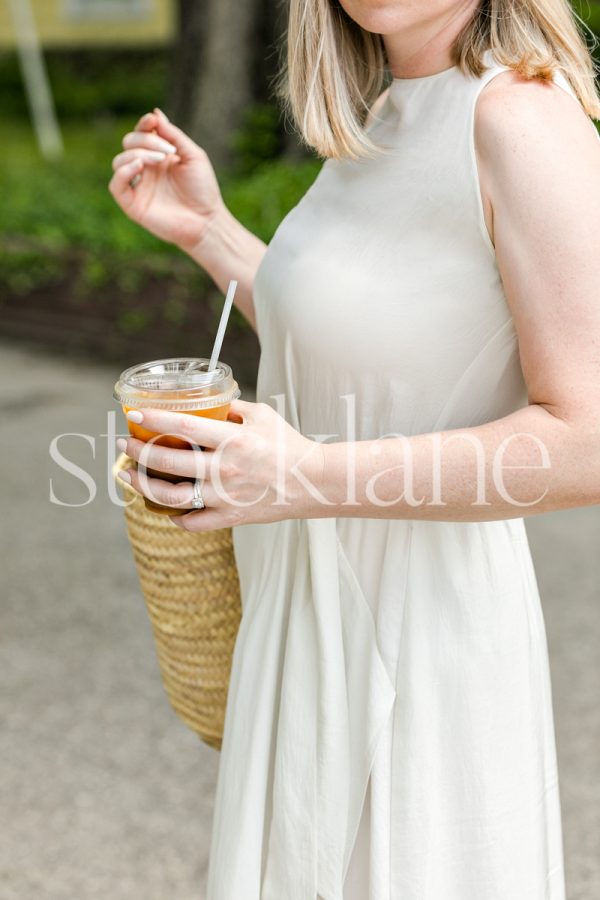 Vertical stock photo of a woman with iced coffee