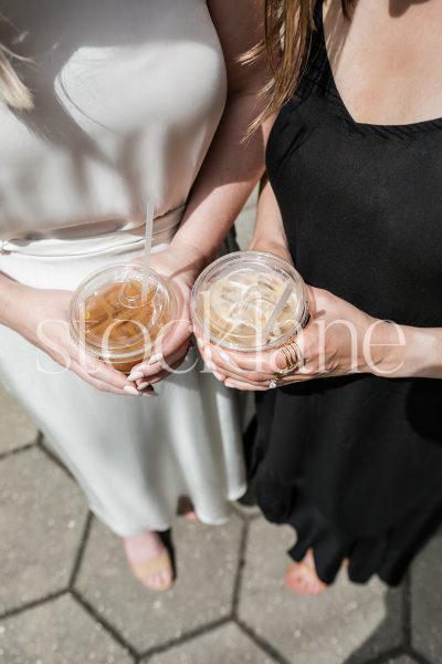 Vertical stock photo of two women with ice coffee