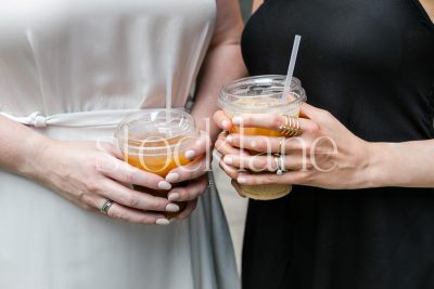 Horizontal stock photo of two women holding iced coffees.