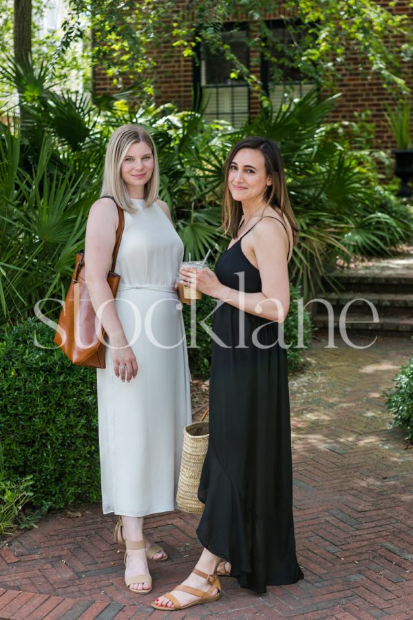 Vertical stock photo of two women chatting in front of a home.