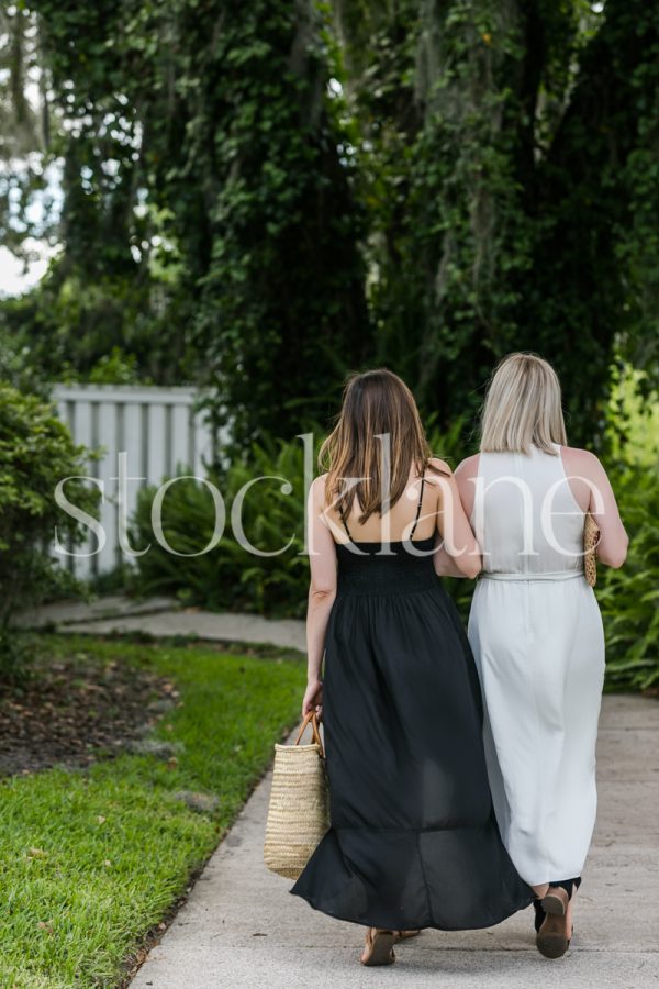 Vertical stock photo of two women walking down the street.