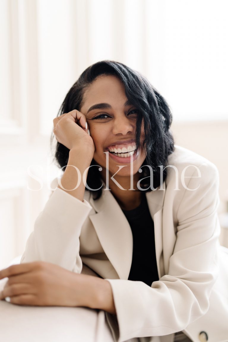 Vertical stock photo of a woman wearing a white suit and black top.