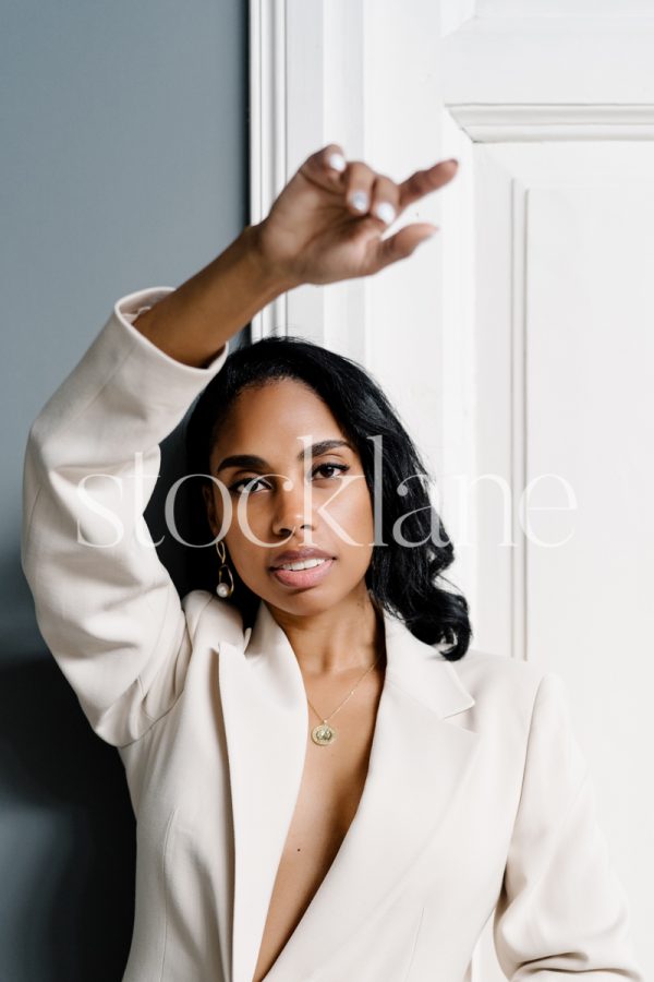 Vertical stock photo of a woman wearing a white suit.