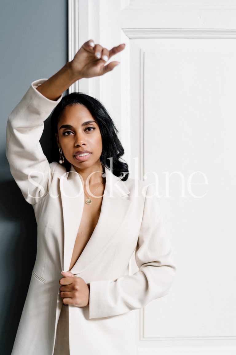 Vertical stock photo of a woman wearing a white suit.