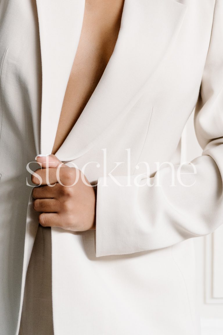 Vertical stock photo of a woman wearing a white suit.