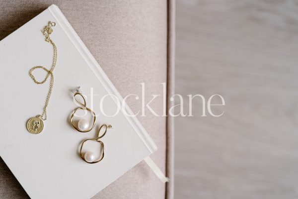 Horizontal stock photo of jewelry on a neutral colored notebook.