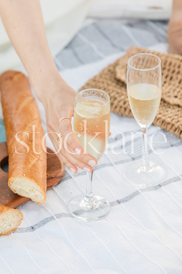 Vertical stock photo of a woman holding a glass of champagne.