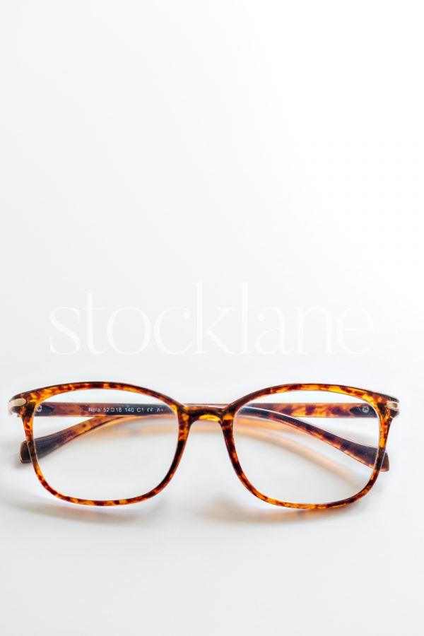 Vertical stock photo of tortoise glasses on a white background.