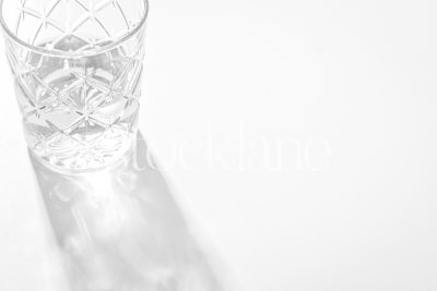 Horizontal black and white photo of a glass with light reflecting through it.