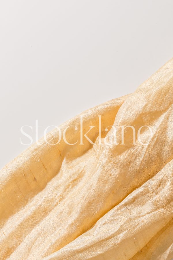 Vertical stock photo of a golden yellow cloth.