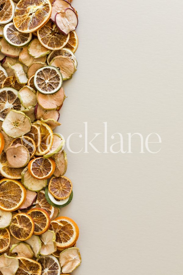 Vertical stock photo of dried fruits arranged on a neutral background.