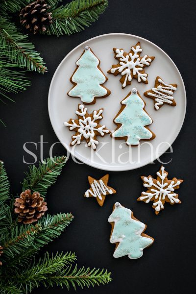 Vertical stock photo of Christmas gingerbread cookies on a black background.