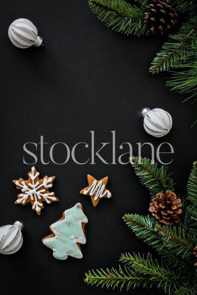 Vertical stock photo of gingerbread cookies on a black background.