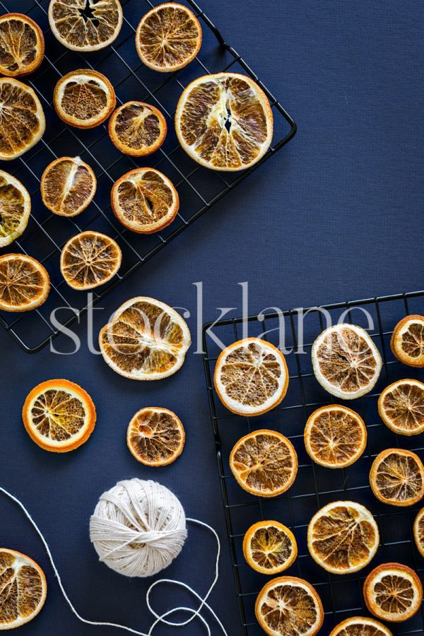 Vertical stock photo of dried citrus on a blue background.