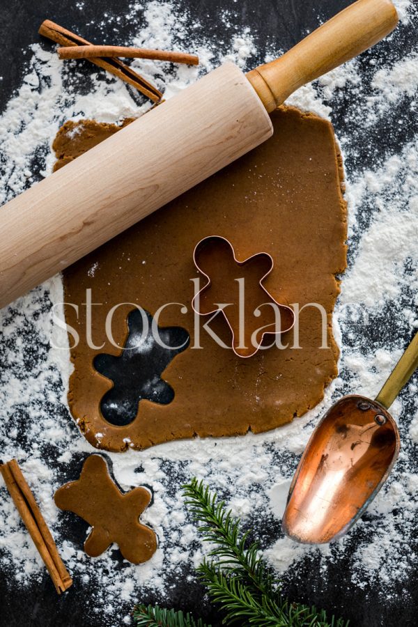 Vertical Christmas stock photo of gingerbread cookie dough, cookie cutters.