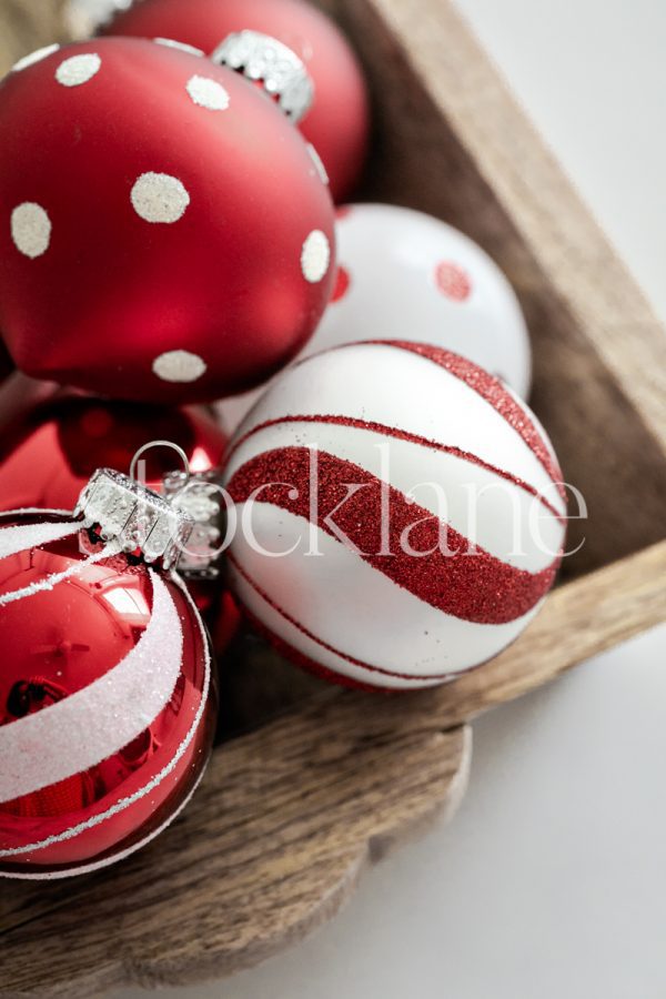 Vertical Christmas stock photo of a wood box with red and white ornaments.