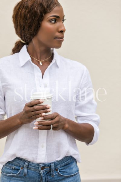 Vertical stock photo of a woman holding a cup of coffee.