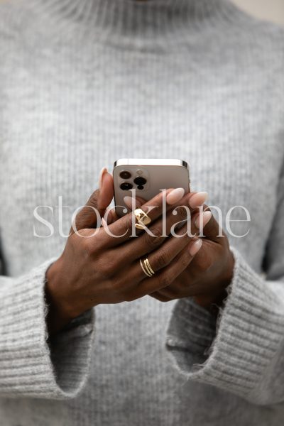 Vertical stock photo of a woman holding a phone.