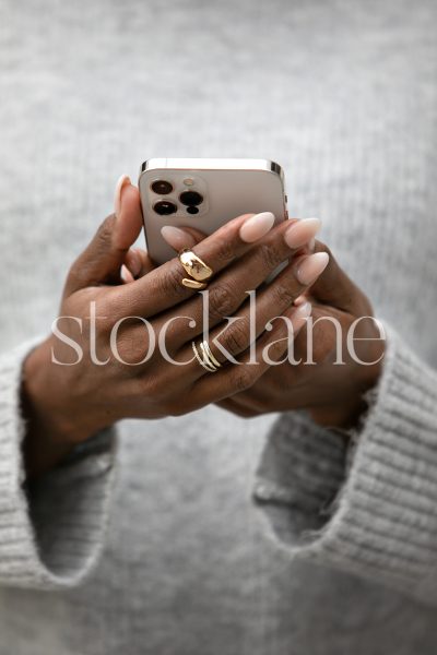 Vertical stock photo of a woman holding a phone.