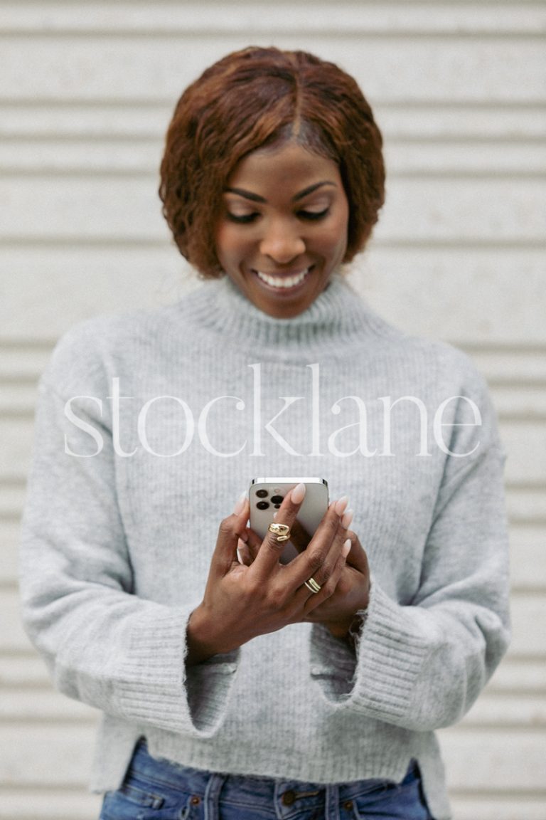 Vertical stock photo of a woman holding a phone.