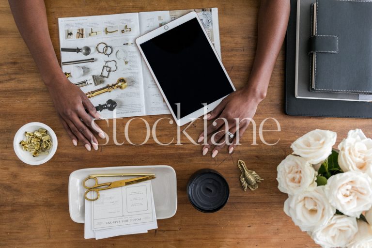 Horizontal stock photo of a woman's hands over her work desk.