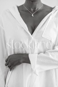 Vertical black and white photo of a woman wearing a white shirt.