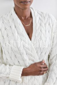 Vertical stock photo of a woman wearing a chunky white sweater.